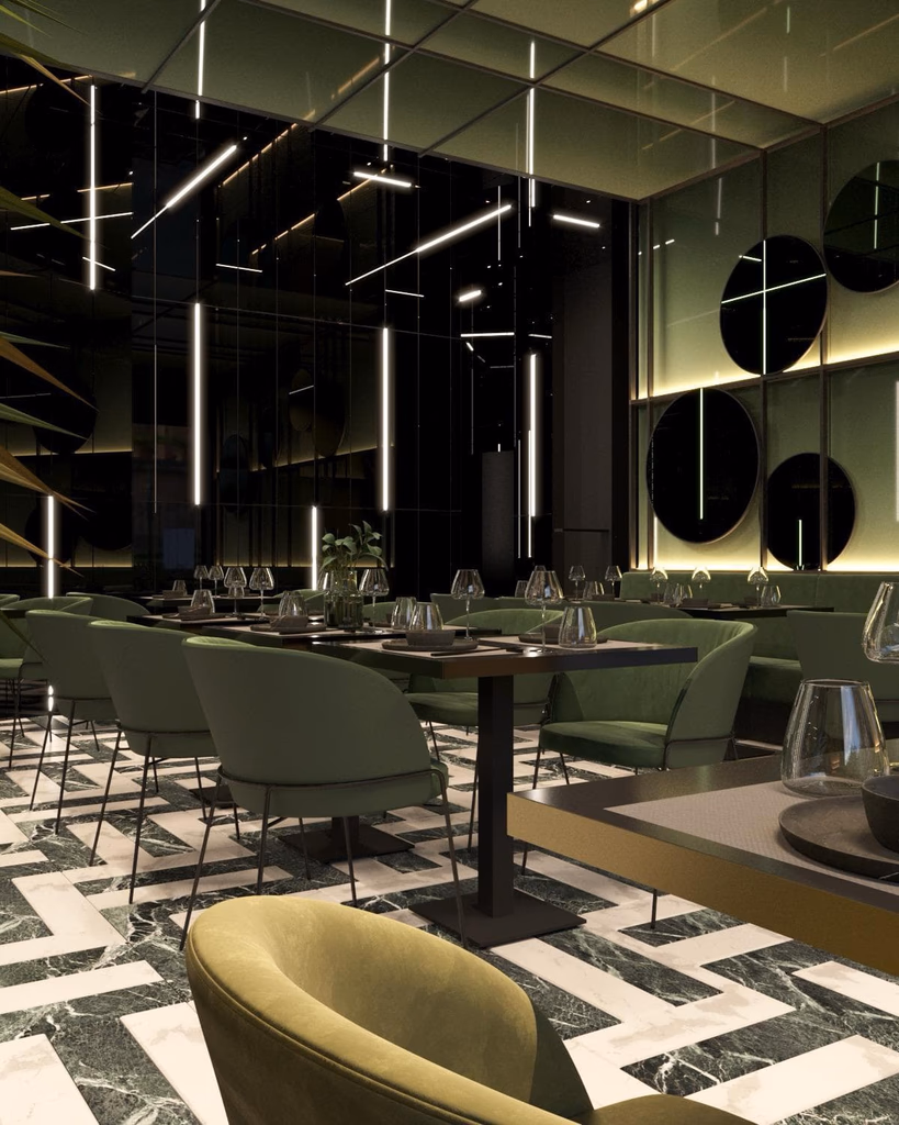 Modern restaurant interior with green upholstered chairs, round mirrors on the wall, and hanging linear light fixtures above.